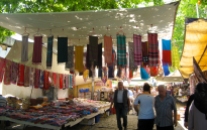 At the main Thursday market in Ayvalik colorful fabrics hand from the shade awnings strung between buildings.